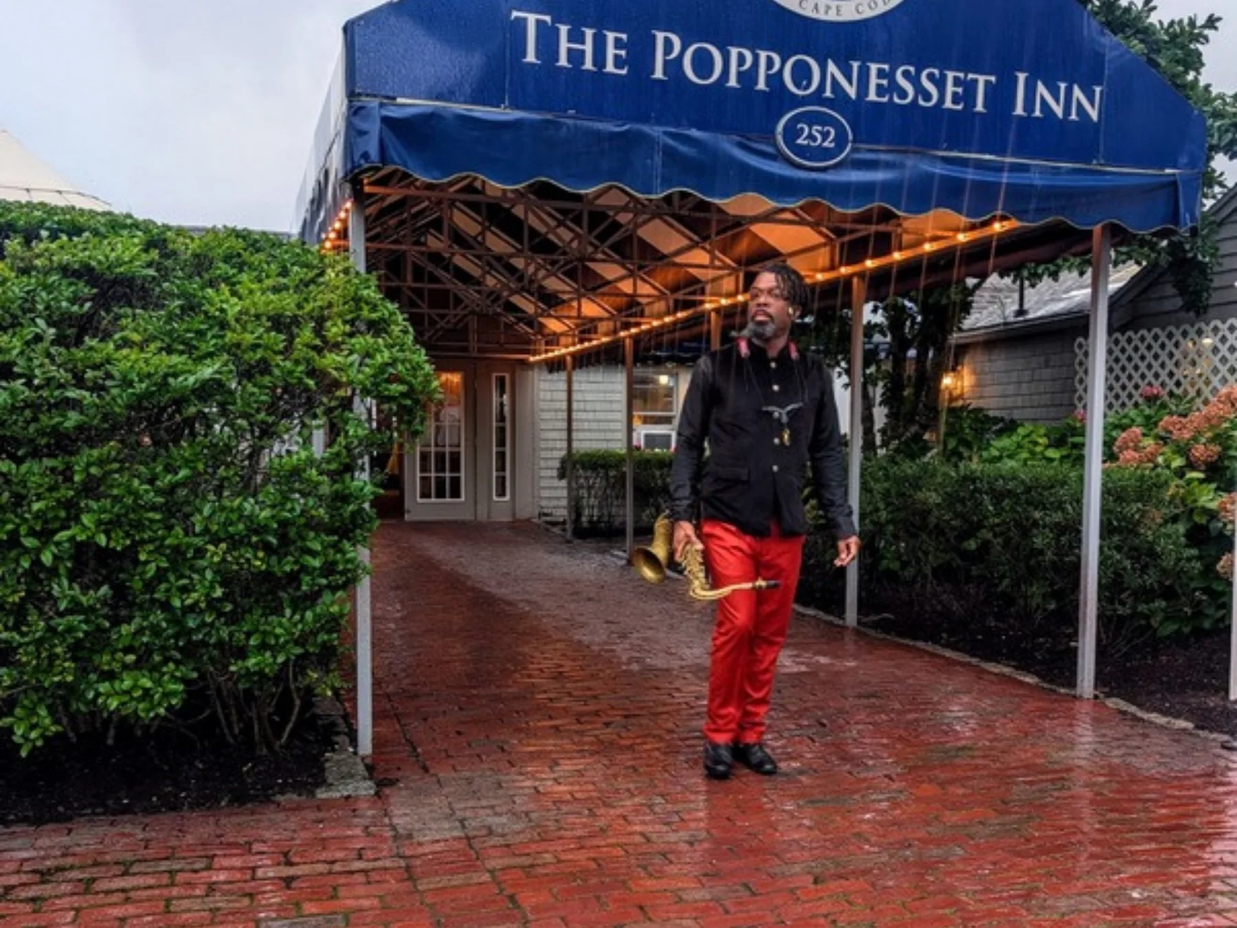 Dennison Blackett with saxophone outside the Popponesset Inn