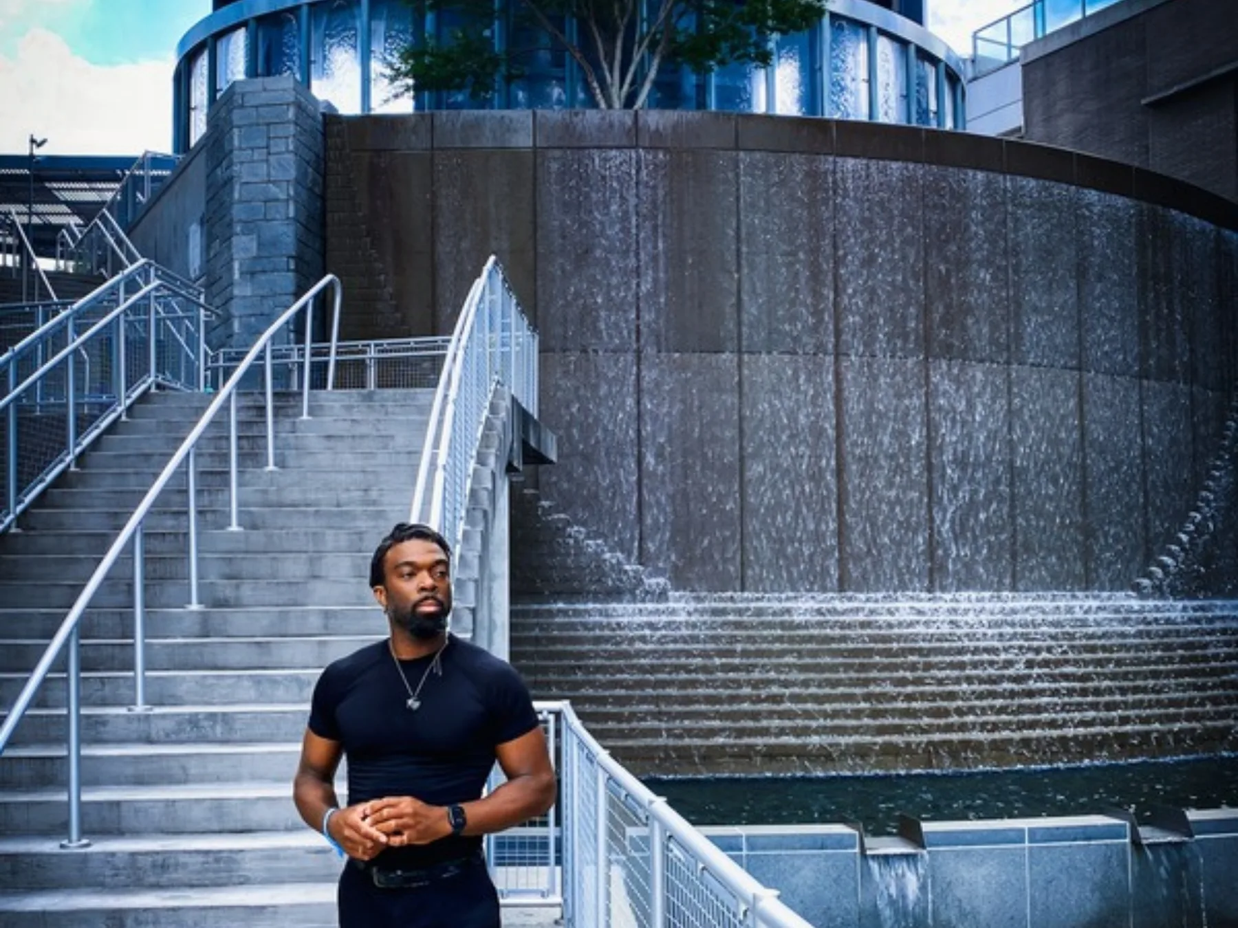 Dennison Blackett at the foot of a stone waterfall staircase